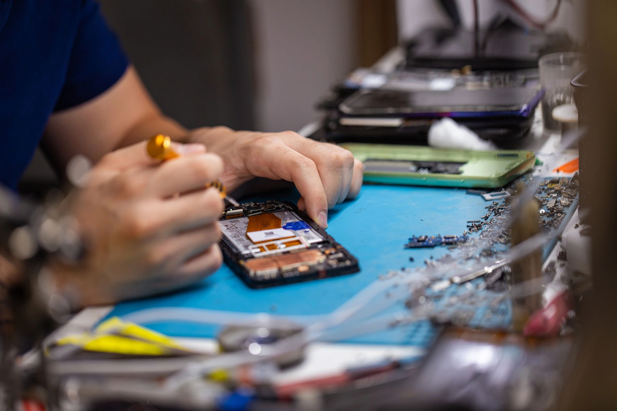 Technician repairing a smartphone on a clean workbench
